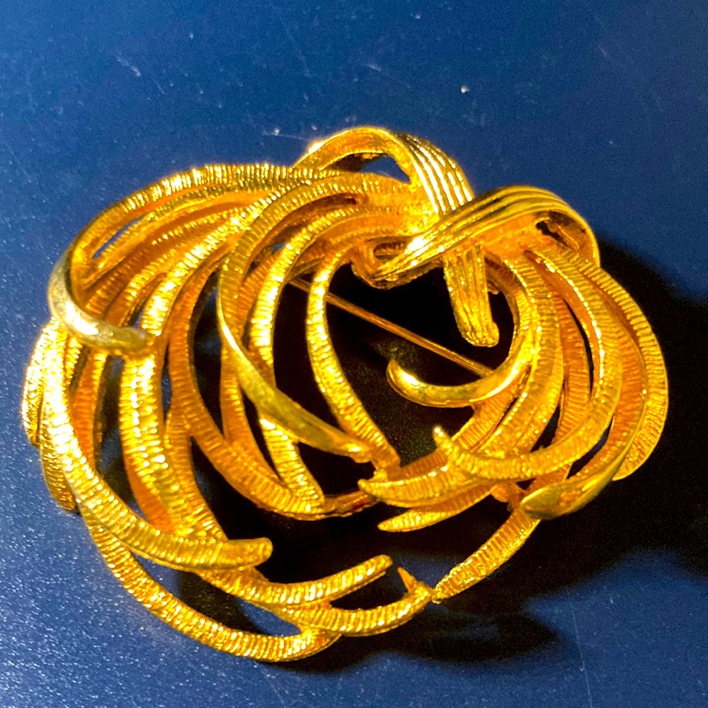 Gold toned swirling brooch